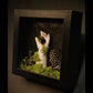 Artistic depiction of a hand holding a bee in a dark box with moss and a honeycomb.