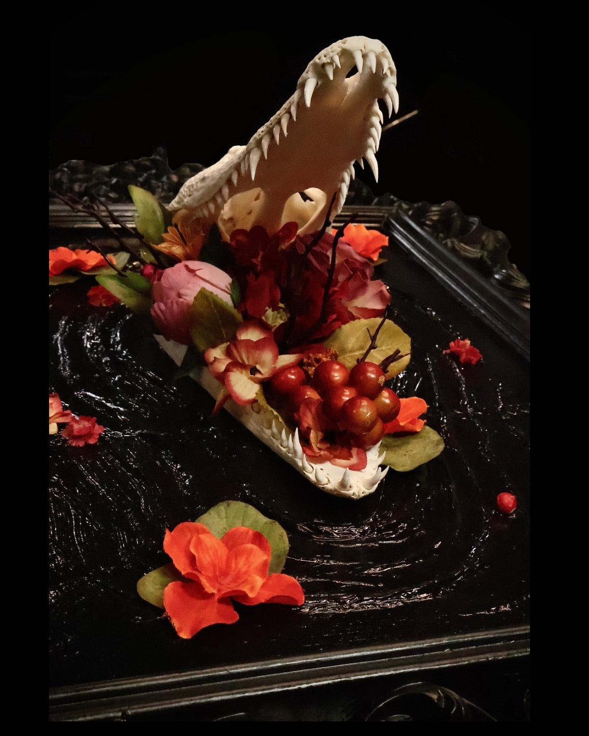 Decorative aligator with floral elements on a dark background 
